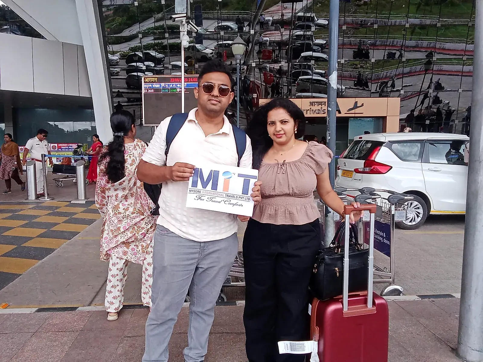 Real MIT travellers welcomed on arrival, holding the MIT signage